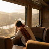 Viaggiatore che riposa al finestrino del treno nella luce dorata — scena Cervicale e Viaggio